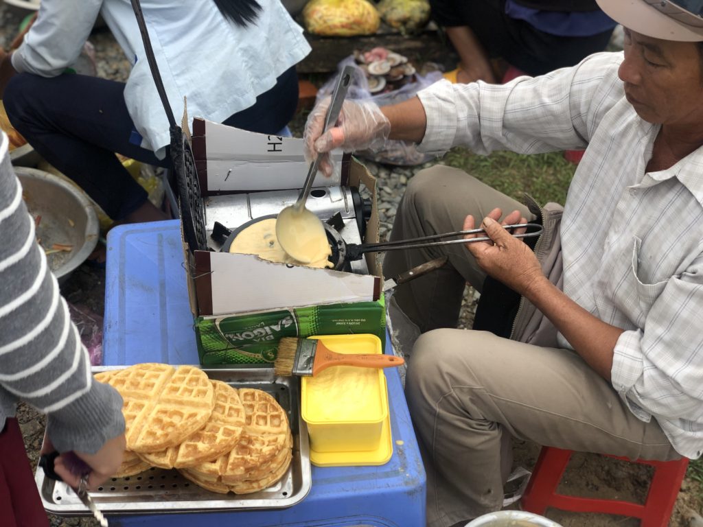 A Vietnamese man baking waffles