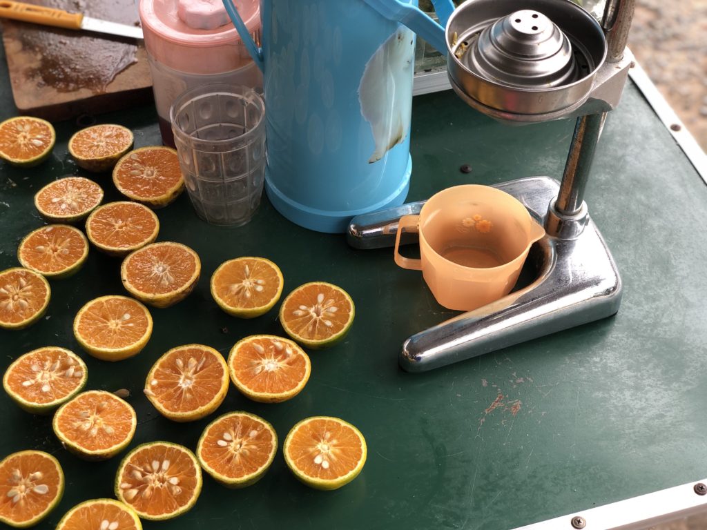 Lots of Vietnamese oranges cut in half and squeezed with a manual juicer