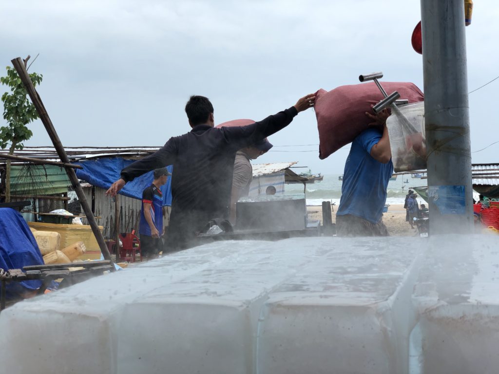 Fishery workers using a crusher to crush icicles as thick as building columns into usable sizes and transport them to the boat