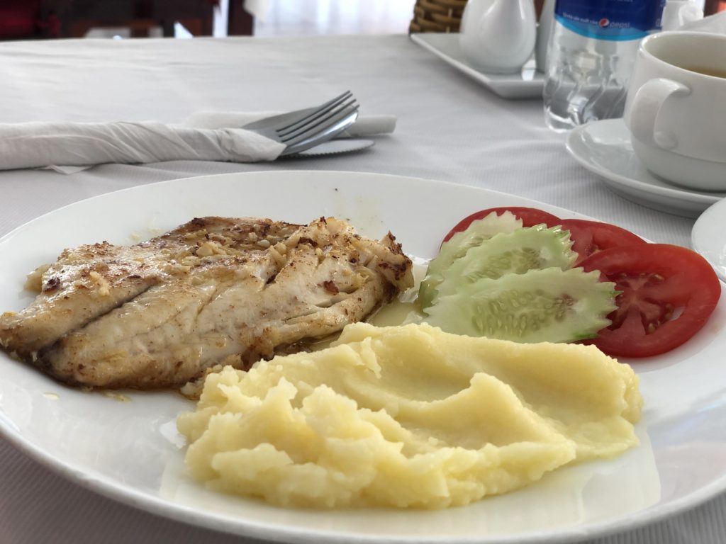 Fish, mashed potatoes and tomatoes on a plate