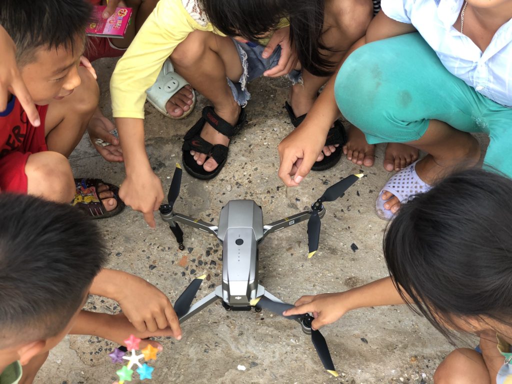 Vietnamese children gather around a landed drone