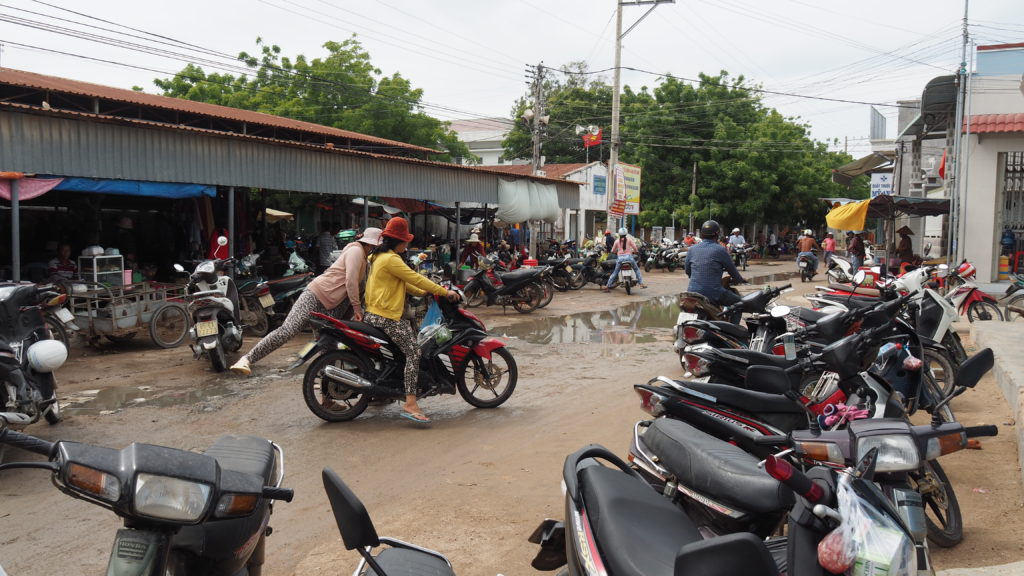 In front of the Vietnamese market, lined with motorbikes