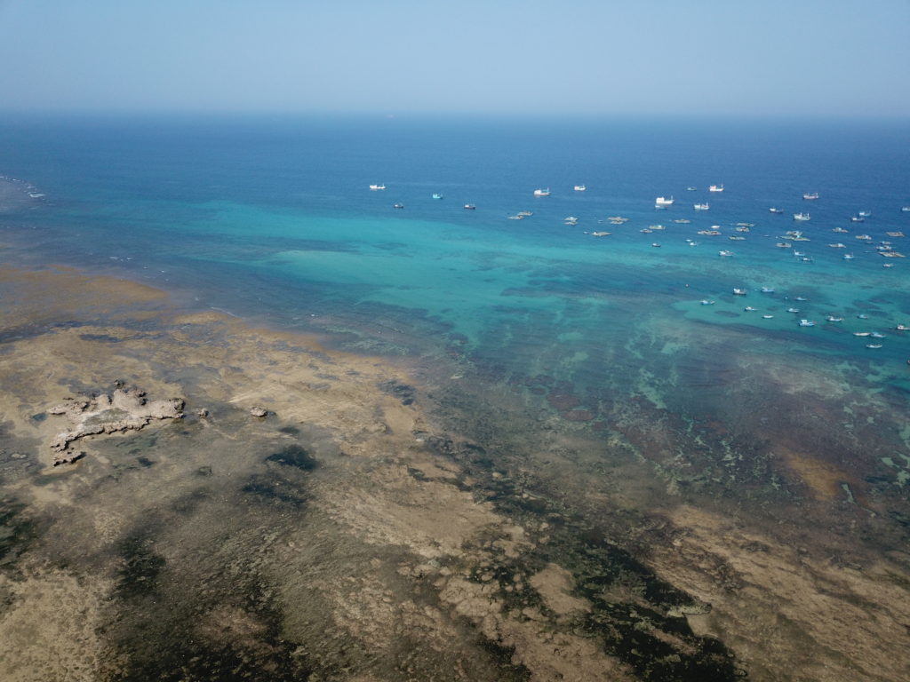 上空からファンラン＝タップチャムの珊瑚礁と海を眺める、綺麗な青い海と黒い汚れ